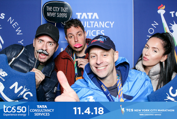 three men and 1 woman smiling and holding props 