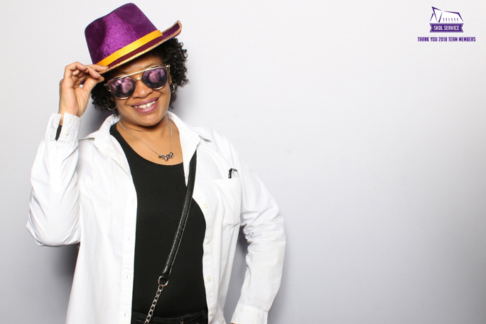 a photo of a woman wearing sunglasses and a purple hat 