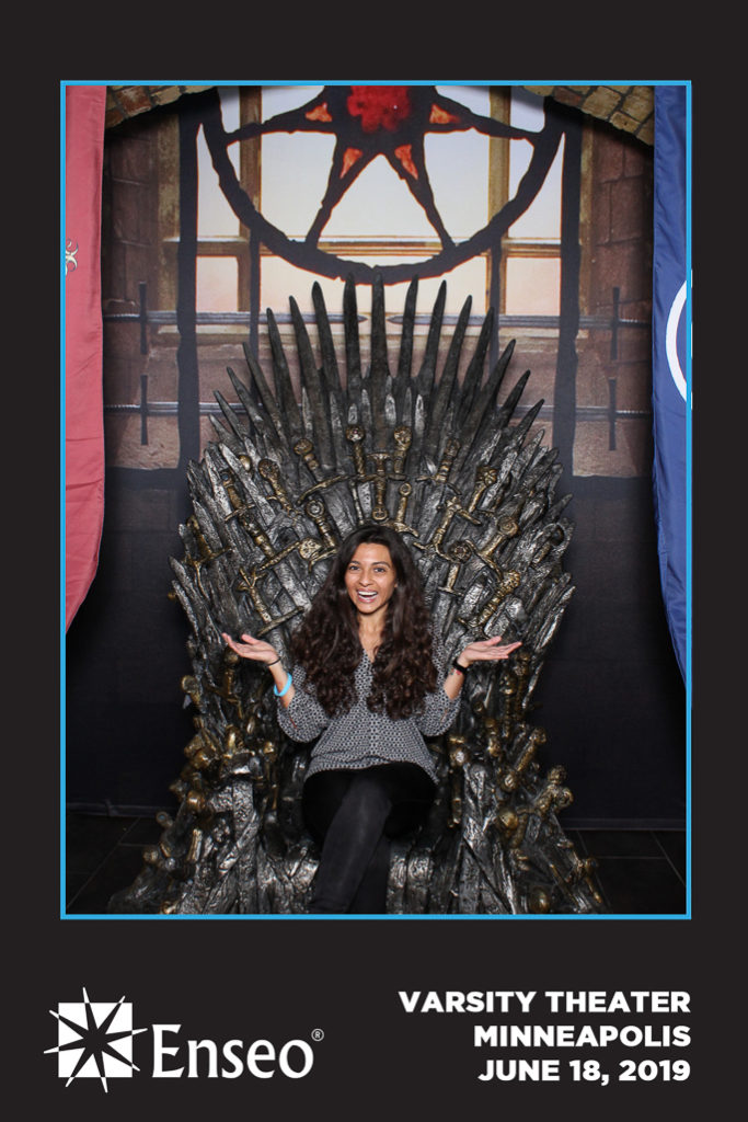 A woman is smiling and sitting on a throne 