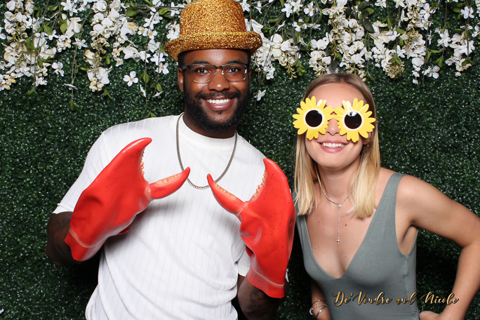 A couple smiling and wearing props