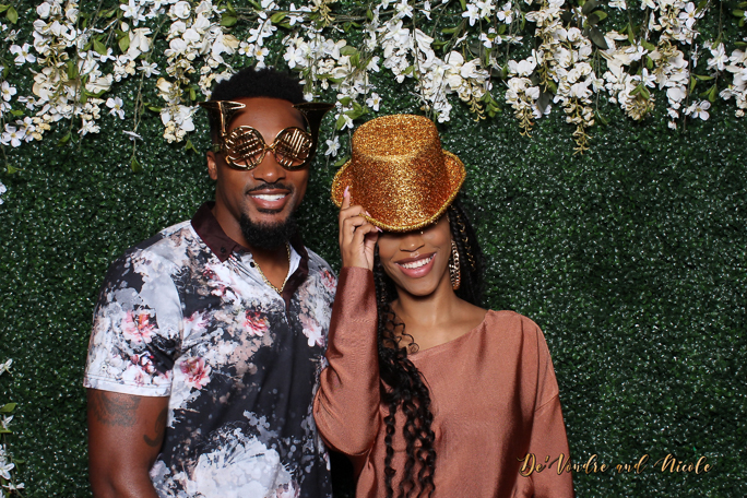 A couple smiling for a photo wearing props