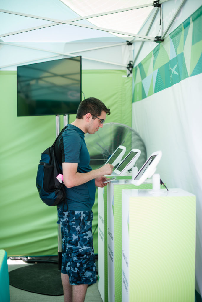 A man next to a kiosk with tablet