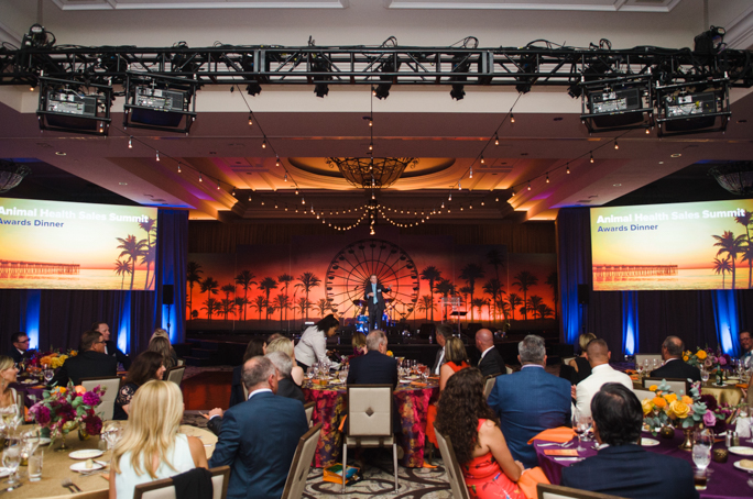 People listening to a men speaking on stage 