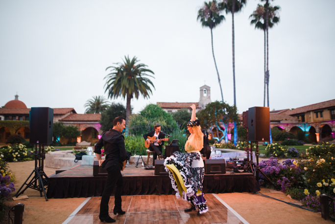 A couple dancing next to palm trees and a band playing 