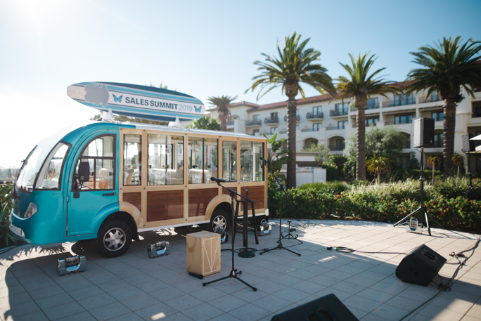 A bus next to microphone and palm trees