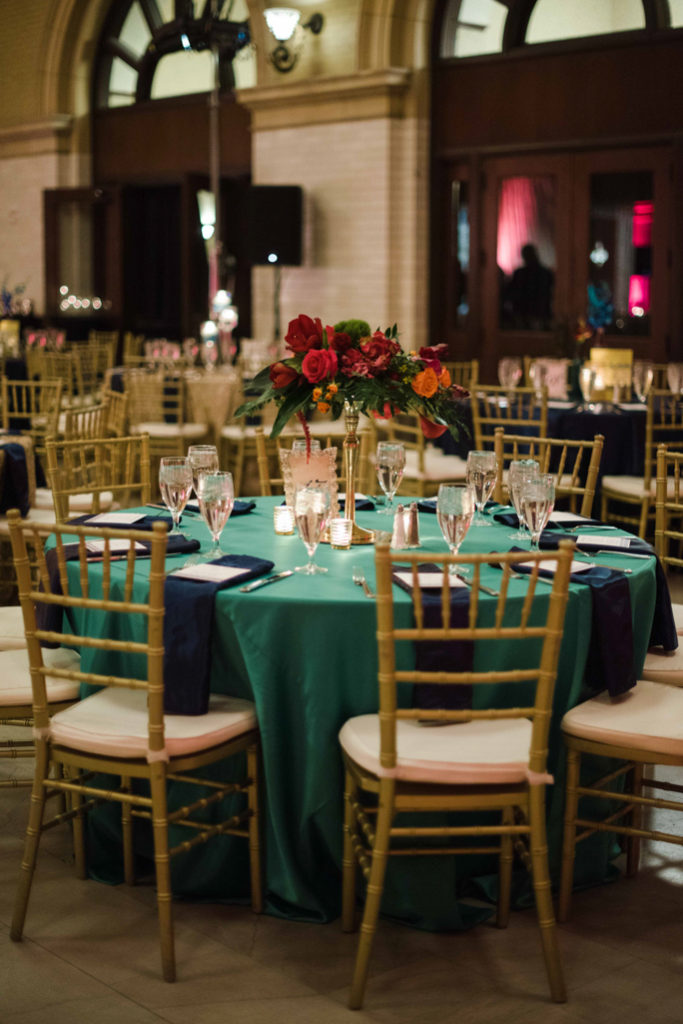 A table with green tablecloth and flowers 