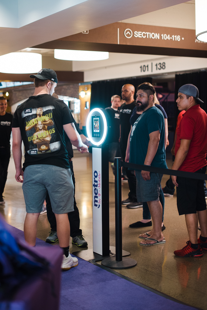 A group of people next to a kiosk 