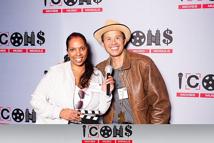 Two people smiling and holding a microphone