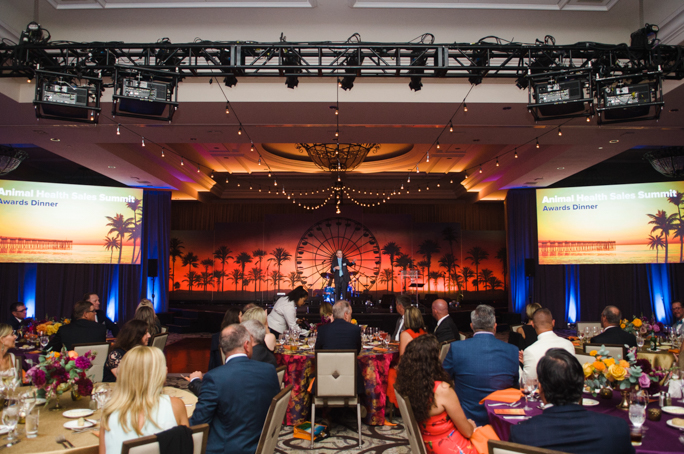 People listening to a men speaking on stage
