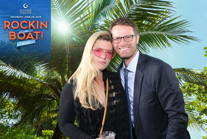a couple smiling next to a palm tree