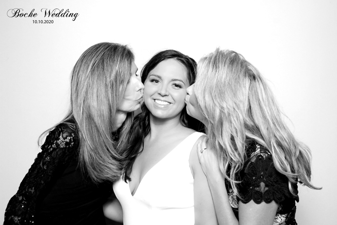 Two women are kissing a women on a cheek 