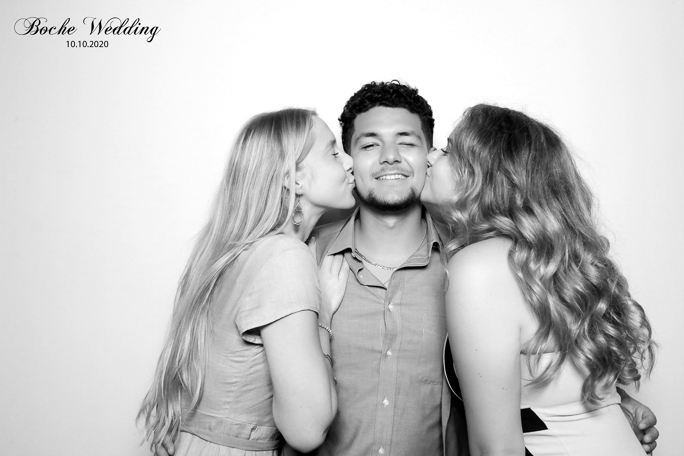 Two women kissing a man