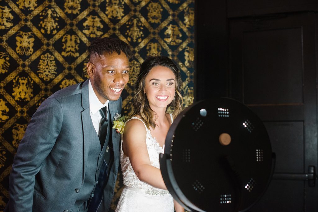 A bride and groom using a drop-off photo booth