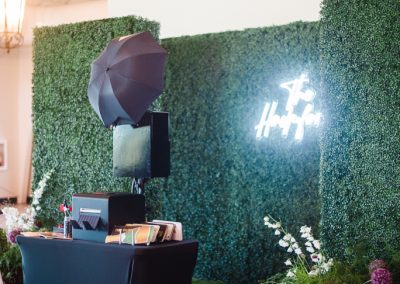 An open style booth by a hedge backdrop
