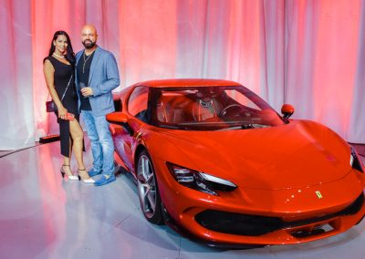 a couple by a red car