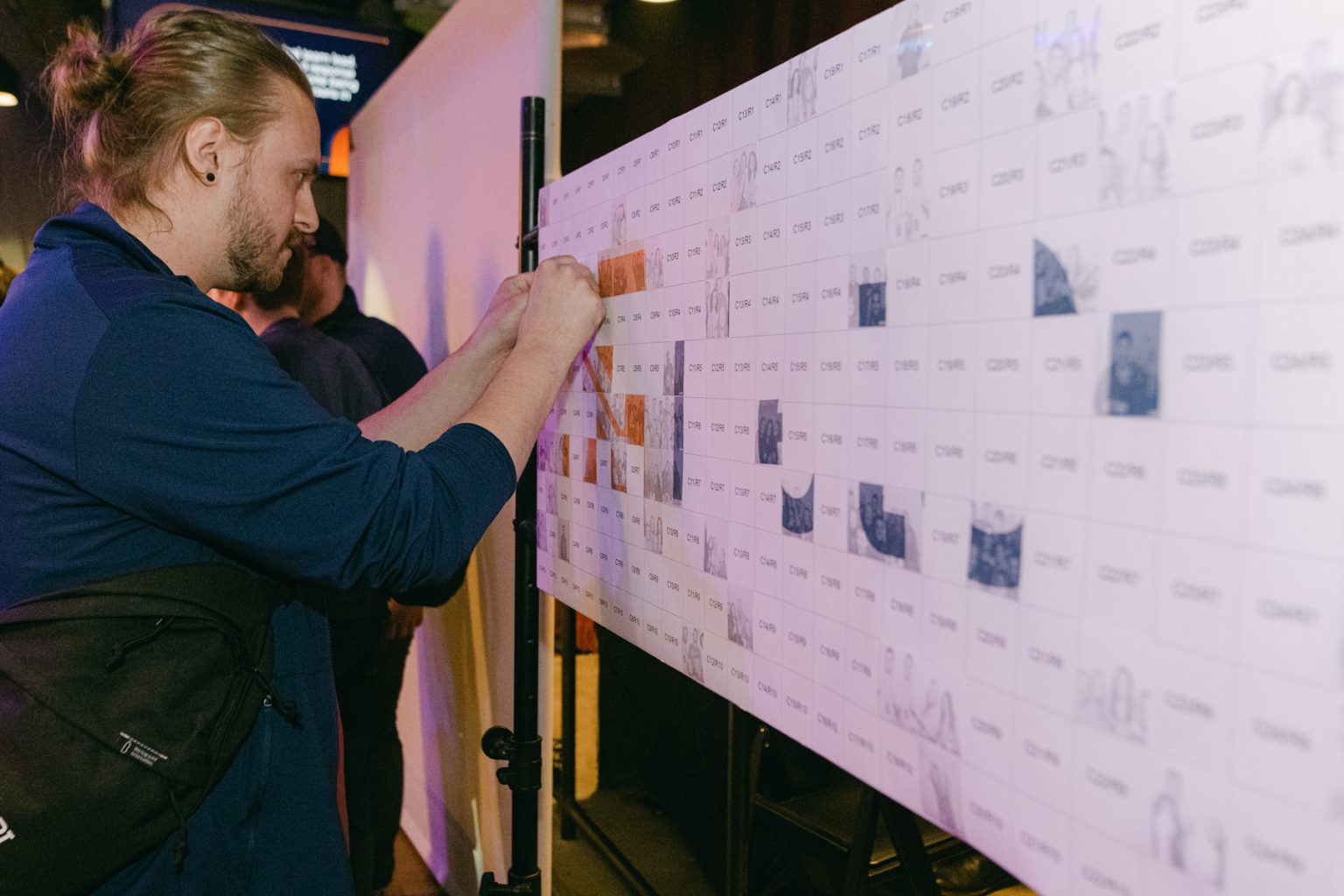 Guests adding photos to a mosaic wall at a Minneapolis event