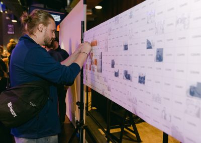 A man is adding a tile to a photo mosaic wall
