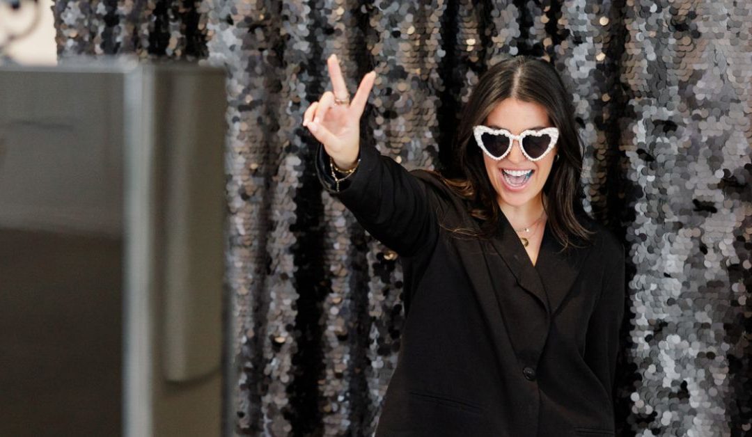 Woman giving a peace sign in front of a photo booth