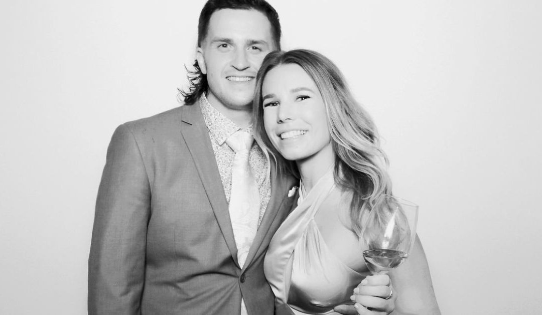 A man and woman pose for a photo booth picture