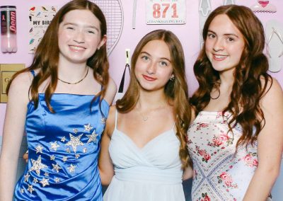 Three teen guests posing in front of a custom bat mitzvah photo booth backdrop in Minneapolis