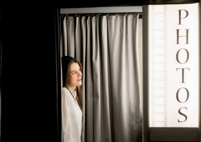 Guest stepping into an enclosed photo booth rental at a corporate event venue in Minneapolis