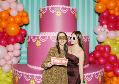 Mother and daughter posing with a Turn Up sign at a custom mitzvah party photo booth backdrop