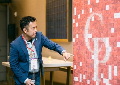 Attendee finding his photo on a branded photo mosaic wall at a corporate event in Minneapolis