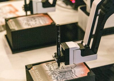 Sketch Bot fleet - two drawing robots sketching branded portraits side by side at a brand activation