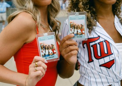Guests holding custom sports trading cards from a photo booth brand activation at a Minnesota Twins Generosity Night