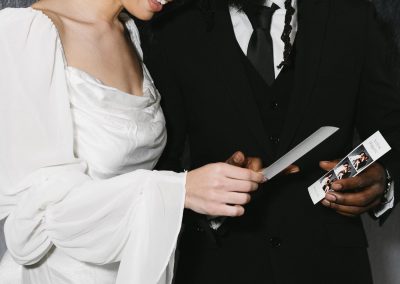 Bride and groom laughing at their photo booth photo strip at a Minneapolis wedding