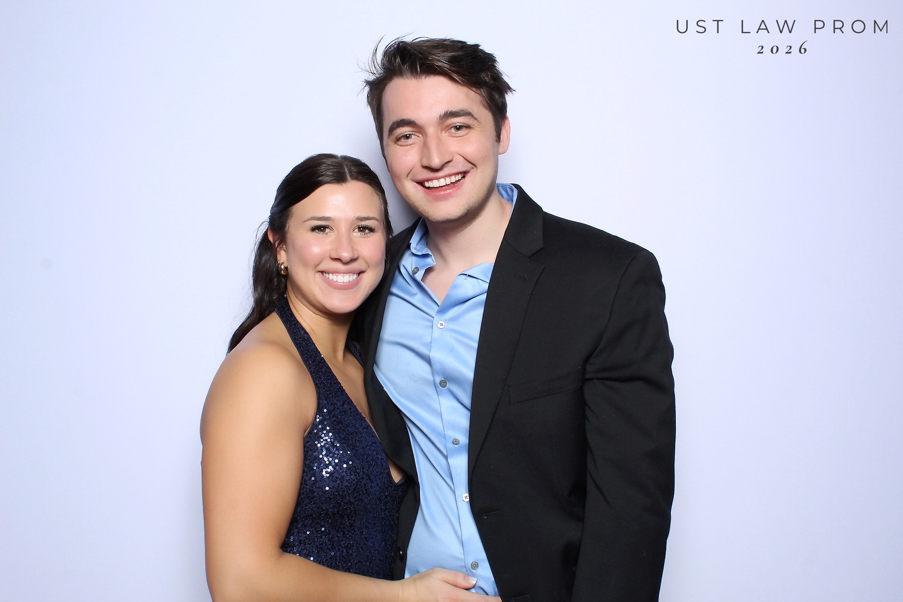 Color glam photo booth portrait of a smiling couple in evening wear on a soft light backdrop