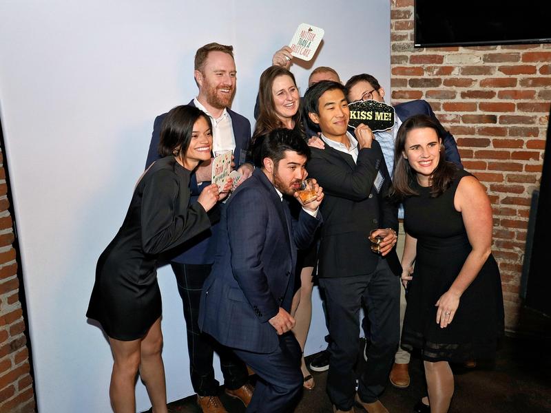 Company party guests packed into one open style photo booth frame