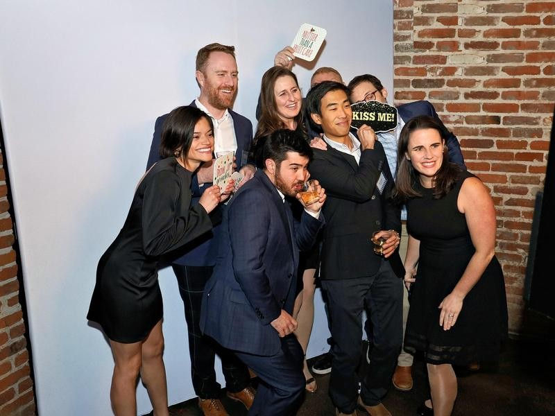 Company party guests packed into one open style photo booth frame