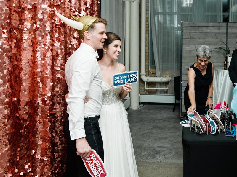 Couple posing at a rose gold sequin backdrop open style photo booth
