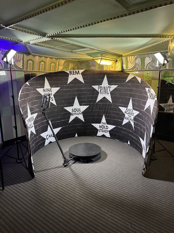 360 photo booth inside a curved black star wall backdrop