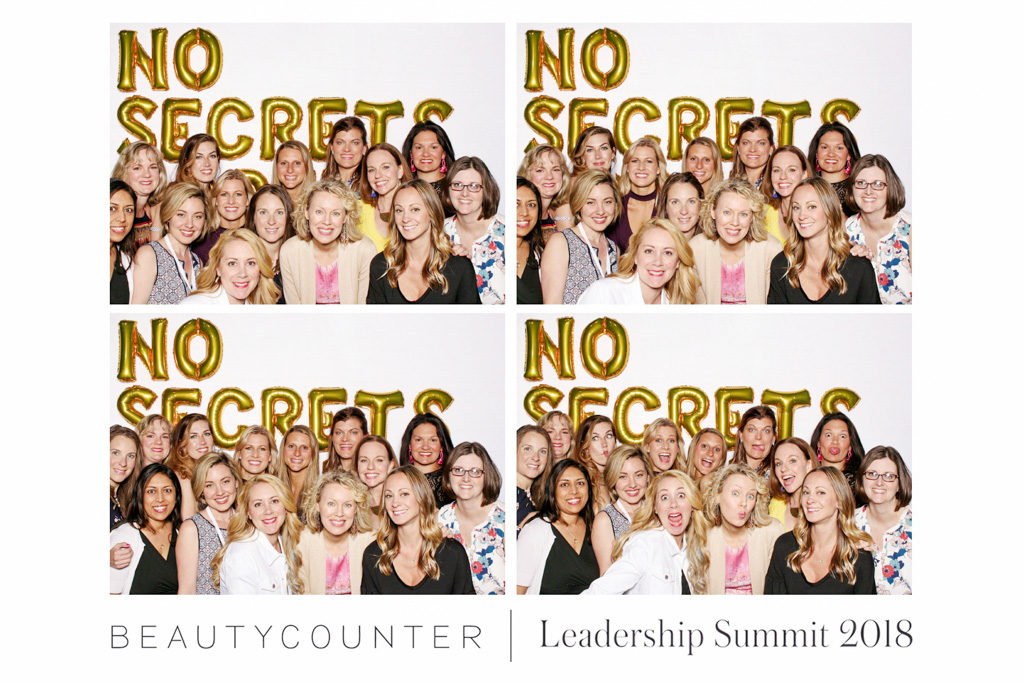 Beautycounter leadership summit print with a large group of women under No Secrets gold balloons