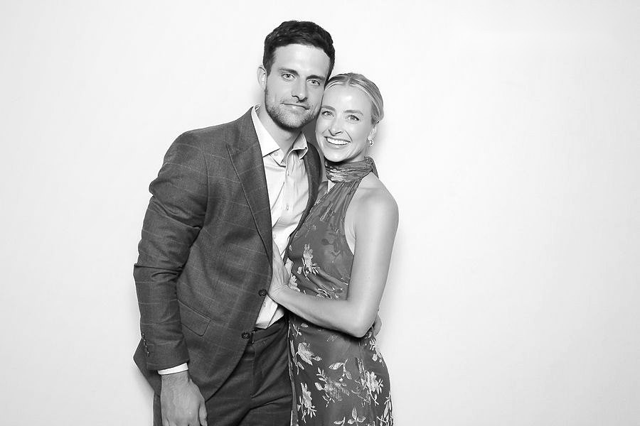 Black and white glam photo booth portrait of a couple on a bright white backdrop