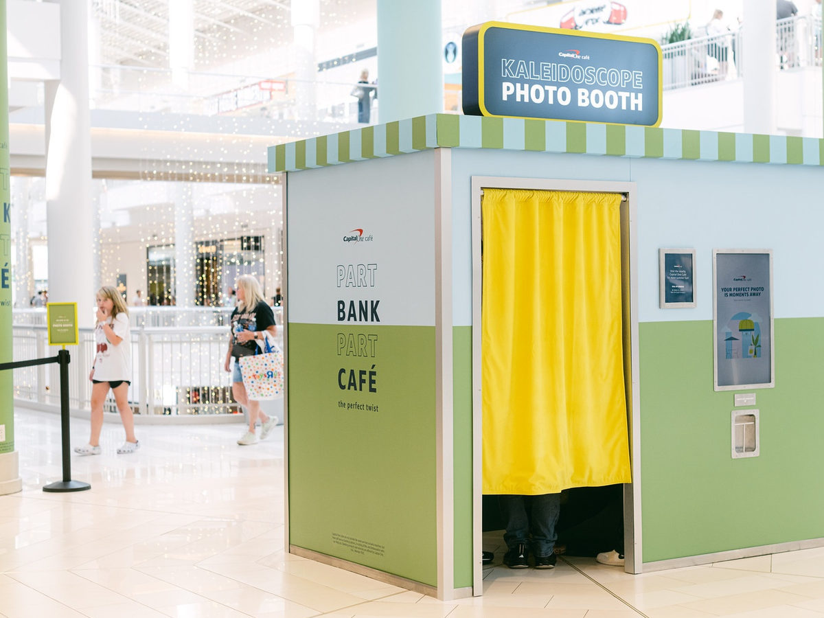 Custom built photo booth wrapped in brand colors and signage at a shopping mall activation