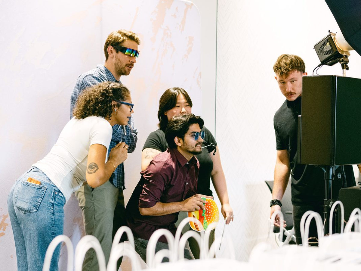 Guests gathered around a photo booth screen sharing their photos at a corporate event