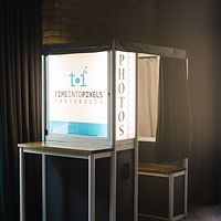 Enclosed photo booth with a lit logo panel