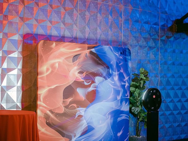 Photo booth in front of a custom art backdrop at a corporate holiday party