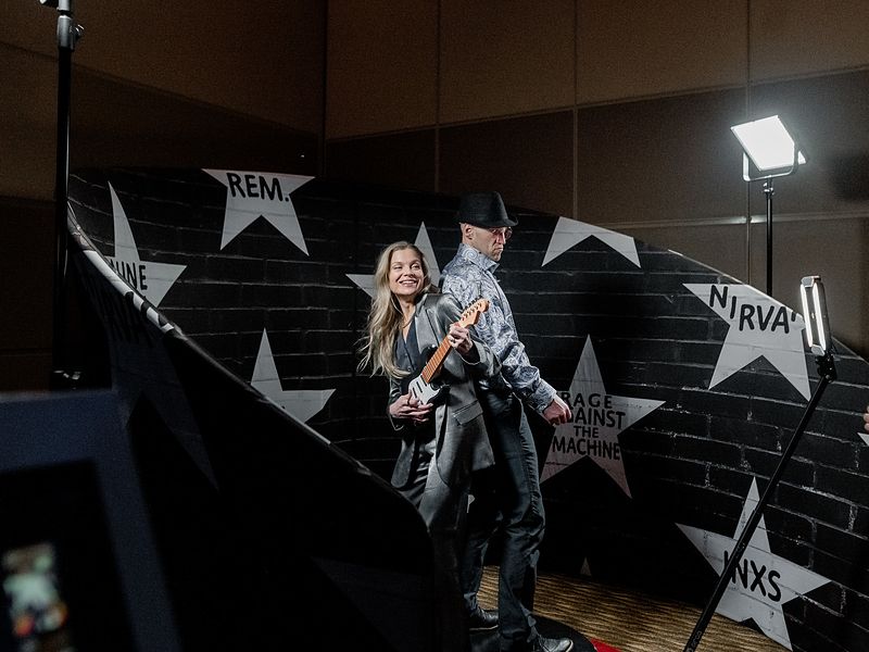 Guests on a 360 photo booth inside a custom star wall backdrop