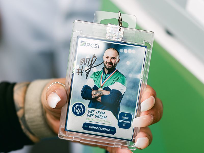 Guest holding a custom trading card in a protective case printed at a corporate brand activation
