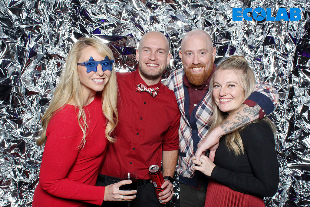 Ecolab party print of four coworkers in front of a crinkled silver foil backdrop