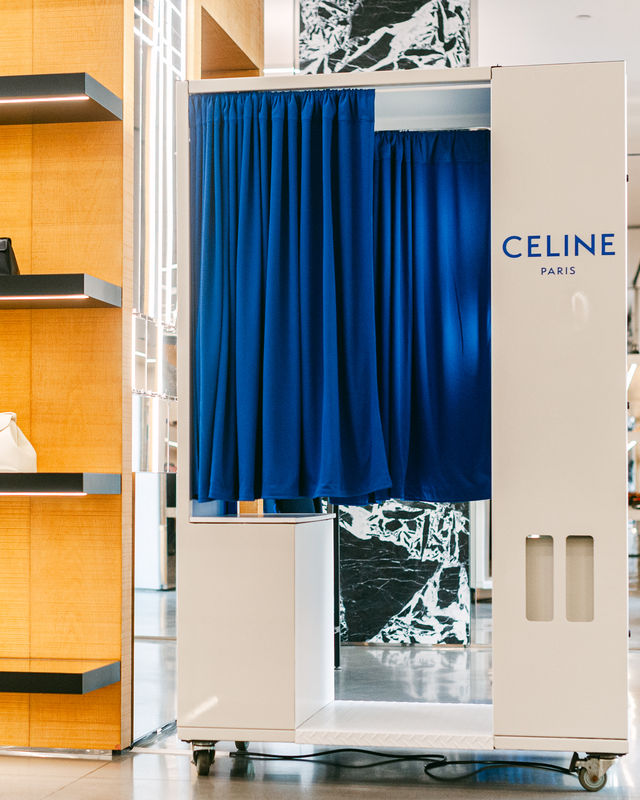 White enclosed photo booth with blue curtain at a luxury retail store activation
