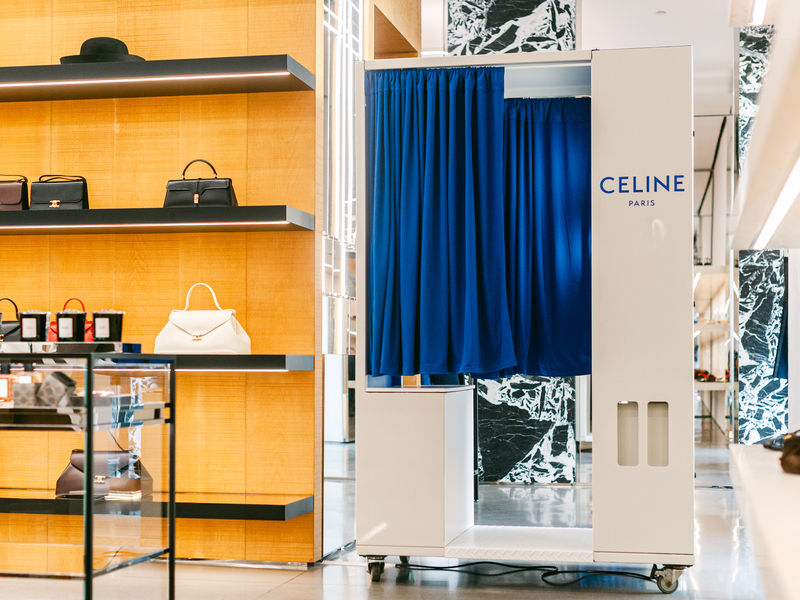 White enclosed photo booth with blue curtain at a luxury retail store activation