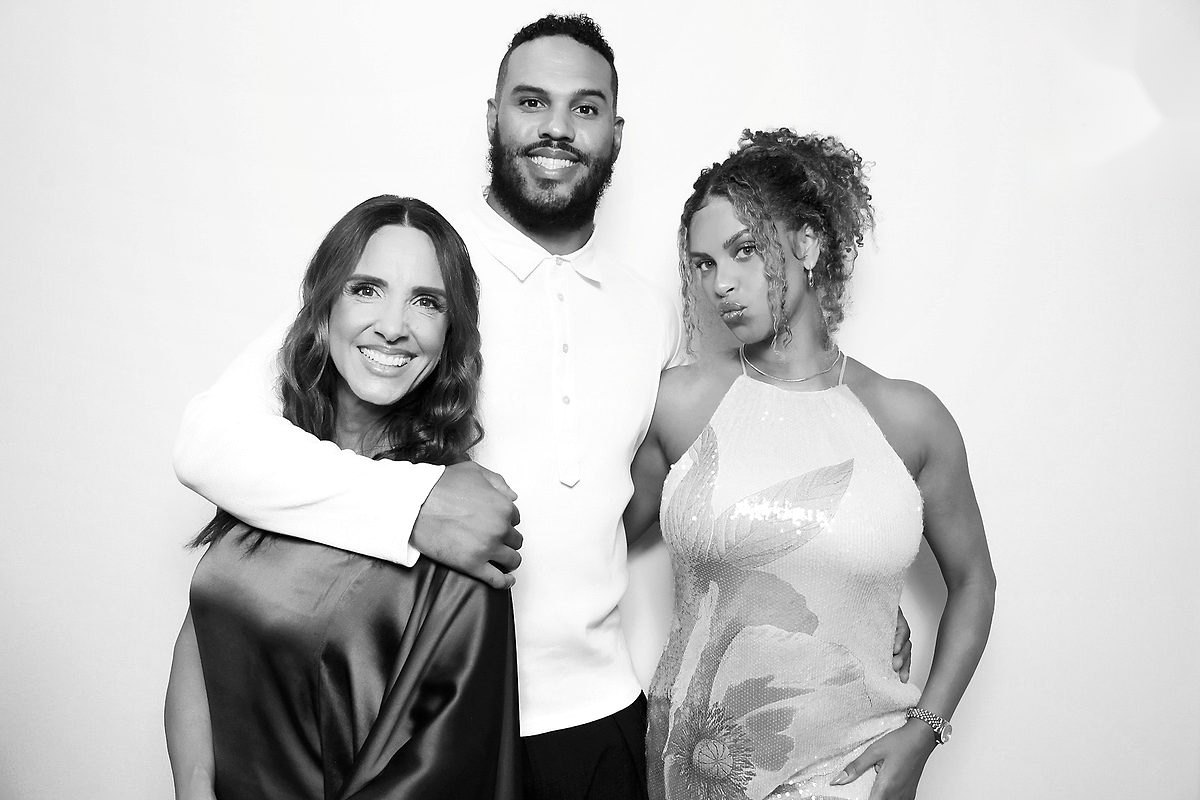 Three guests posing at a corporate gala in a black and white glam photo booth