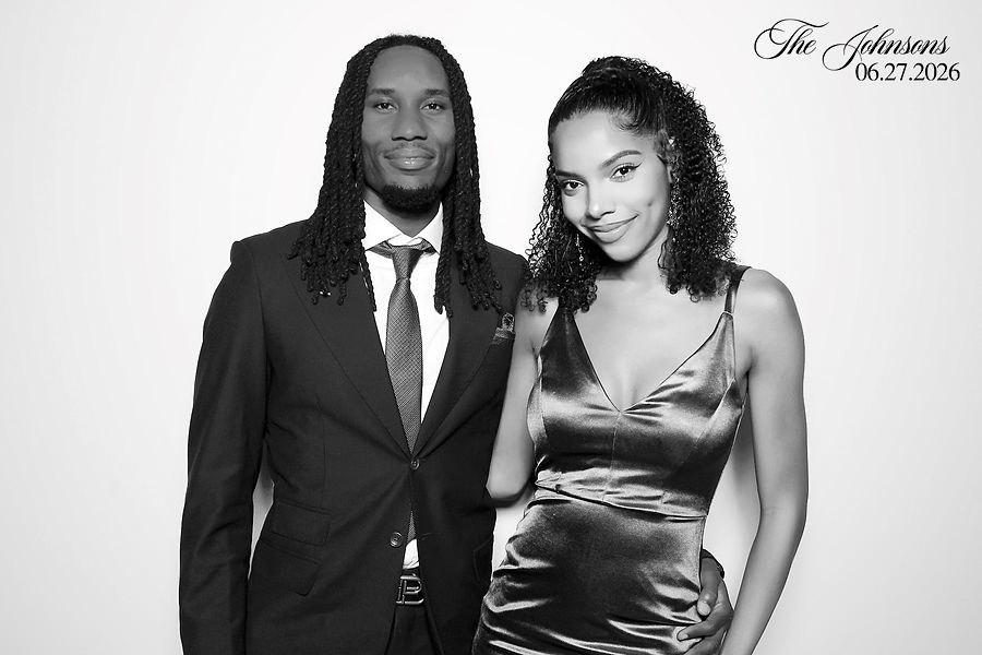 Couple in a dark suit and satin dress in a glam photo booth portrait