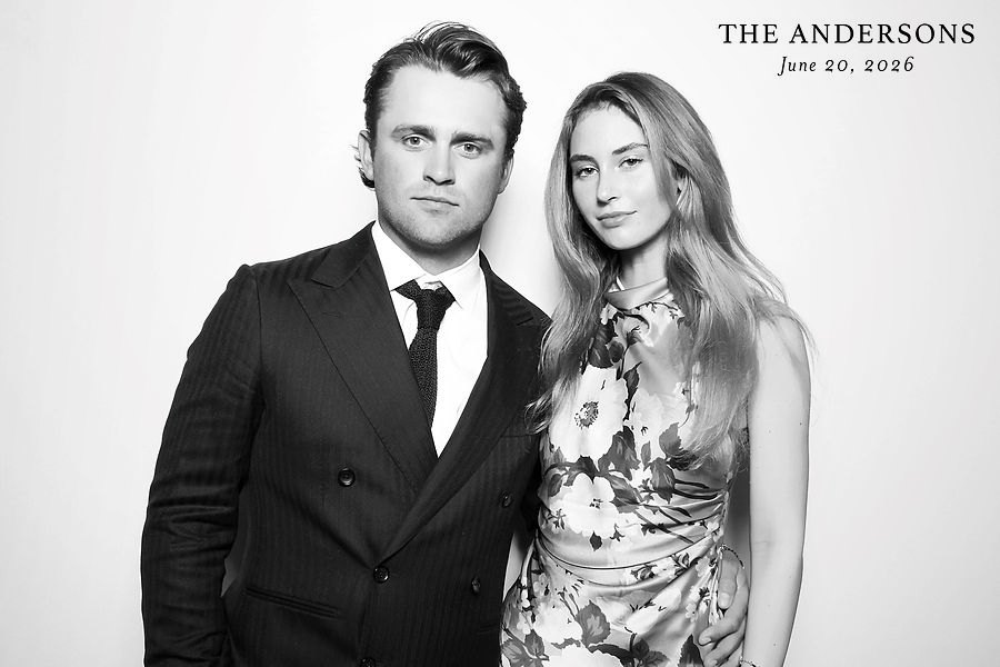 Couple in a pinstripe suit and floral dress in a black and white glam photo booth