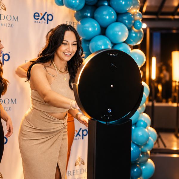 Photo booth at a gala with a blue balloon arch by Time Into Pixels